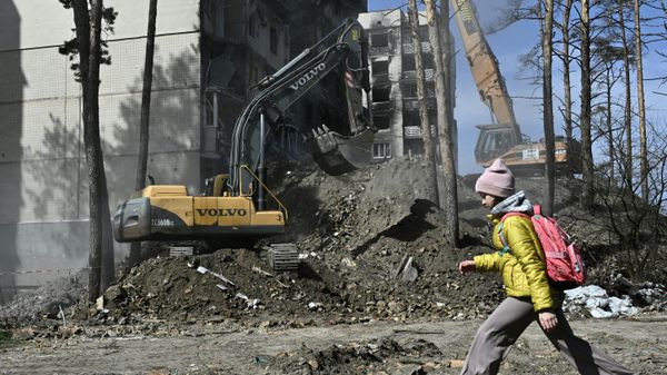 A girl walks past a heavily damaged residential building in the town of Irpin, on April 21, 2023. - Sputnik International