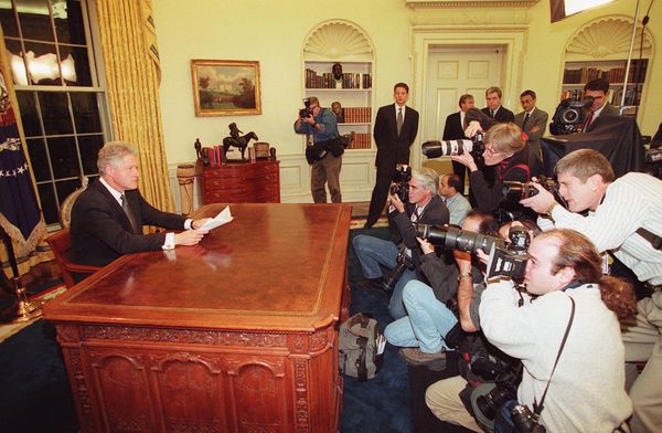 Photographers take pictures of US President Bill Clinton as he prepares to address the nation on December 16 from the White House in Washington, DC. Clinton's remarks came shortly after Baghdad was rocked by a series of violent explosions and anti-aircraft gunfire that lit up the night sky over the Iraqi capital. - Sputnik International