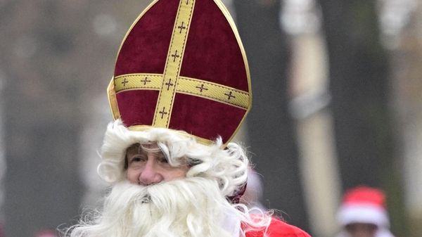 A participant dressed in Santa Claus costume and wearing a miter takes part in the annual Christmas run in Michendorf - Sputnik International