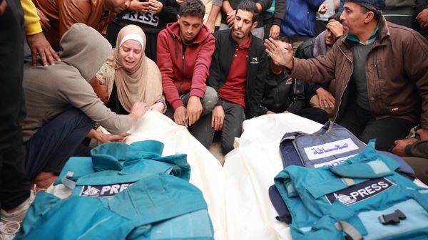 Relatives and colleagues of two Palestinian journalists Hasouna Slim and Sari Mansoor, killed in an Israeli strike, mourn over their bodies during their funeral in Deir al-Balah in the southern Gaza Strip on November 19, 2023 - Sputnik International