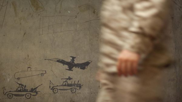 A US military passes by a wall caovered with military graffiti - Sputnik International