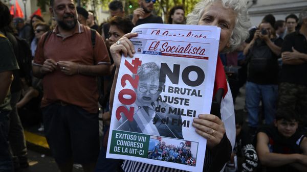 A woman holds a newspaper with a message against the economic adjustment during the first demonstration against the new government of Javier Milei at Plaza de Mayo Square in Buenos Aires on December 20, 2023 - Sputnik International