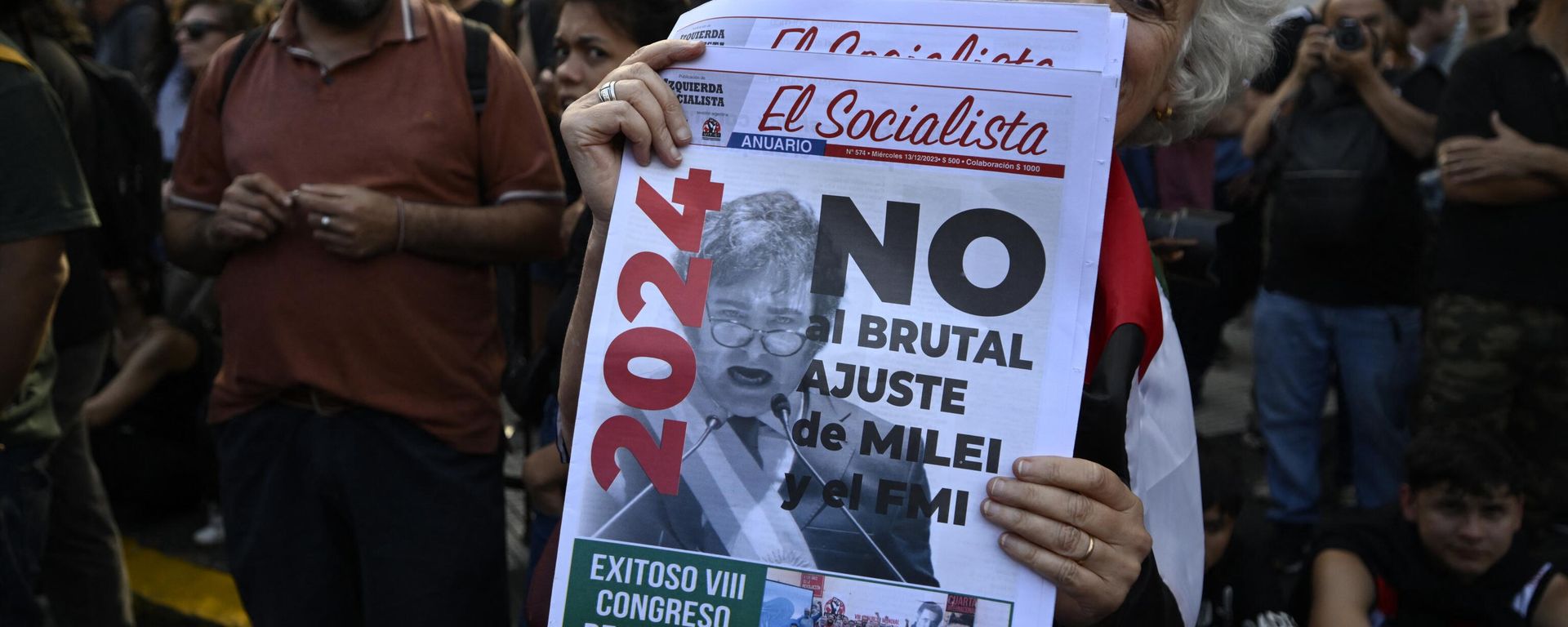 A woman holds a newspaper with a message against the economic adjustment during the first demonstration against the new government of Javier Milei at Plaza de Mayo Square in Buenos Aires on December 20, 2023 A woman holds a newspaper with a message against the economic adjustment during the first demonstration against the new government of Javier Milei at Plaza de Mayo Square in Buenos Aires on December 20, 2023 - Sputnik International, 1920, 20.12.2023