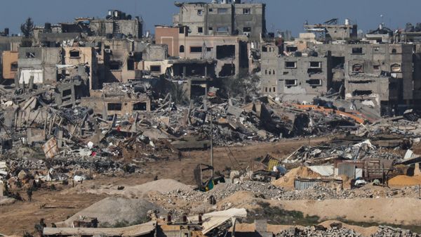 A picture taken from southern Israel bordering the Gaza Strip on December 22, 2023, shows an Israeli army tank rolling past debris of buildings in the Gaza Strip amid ongoing battles with the Hamas militant group.  - Sputnik International