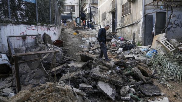 Palestinians walk through the aftermath of the Israeli military raid on Nur Shams refugee camp in the West Bank, Wednesday, Dec. 27, 2023. Israel's forces raided a refugee camp in the northern occupied West Bank, killing at least six Palestinians, Palestinian health authorities said early Wednesday. - Sputnik International