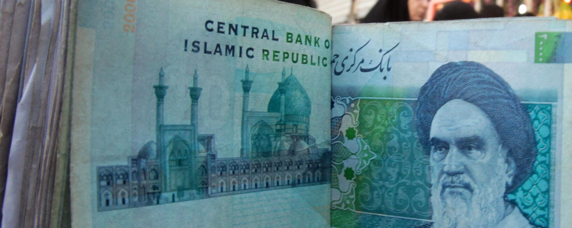 An Iraqi money dealer counts Iranian rial banknotes bearing a portrait of the late founder of the Islamic Republic of Iran, Ayatollah Ruhollah Khomeini, at an exchange office in Baghdad on February 3, 2012 An Iraqi money dealer counts Iranian rial banknotes bearing a portrait of the late founder of the Islamic Republic of Iran, Ayatollah Ruhollah Khomeini, at an exchange office in Baghdad on February 3, 2012 - Sputnik International, 1920, 28.12.2023