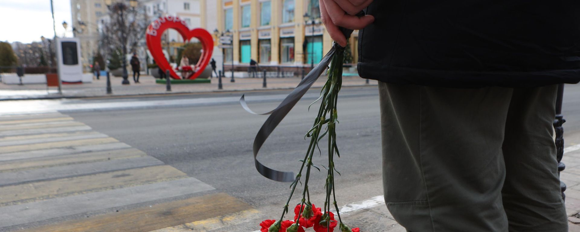 Belgorod resident stands near makeshift memorial to civilians killed in Saturday's Ukrainian missile and MLRS attack on the southwestern Russian city of 340,000. December 31, 2023. - Sputnik International, 1920, 31.12.2023