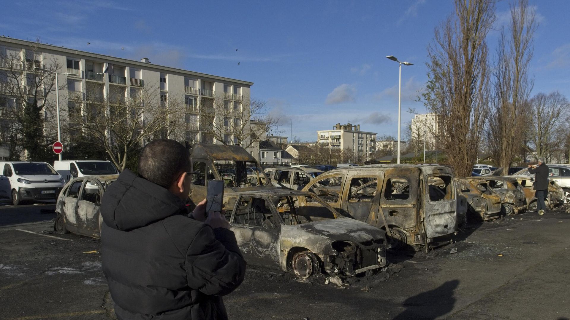 A man takes photographs next to several cars set on fire during the night in a parking in Saint-Pierre-des-Corps, western France, on December 24, 2023 after a young man was hit by a police car on December 23, 2023.  - Sputnik International, 1920, 01.01.2024