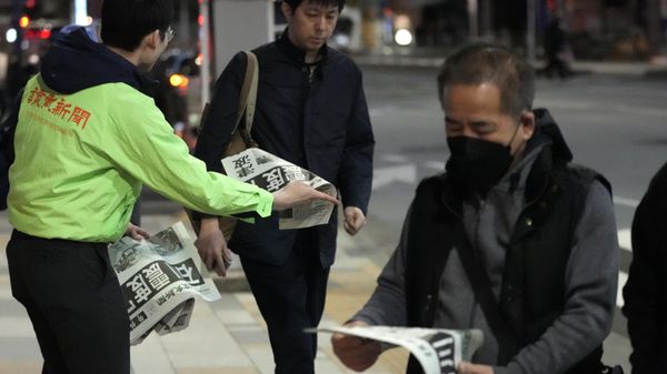 People read extra edition of Yomiuri Shimbun newspaper reporting the earthquakes Monday, Jan. 1, 2024 in Tokyo. Japan issued tsunami alerts and ordered evacuations following a series of earthquakes on Monday that started a fire and trapped people under rubble on the west coast of its main island.(AP Photo/Shuji Kajiyama) - Sputnik International