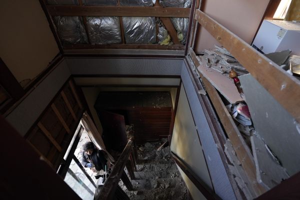 A person looks at a house damaged by a powerful earthquake near the town of Anamizu. - Sputnik International