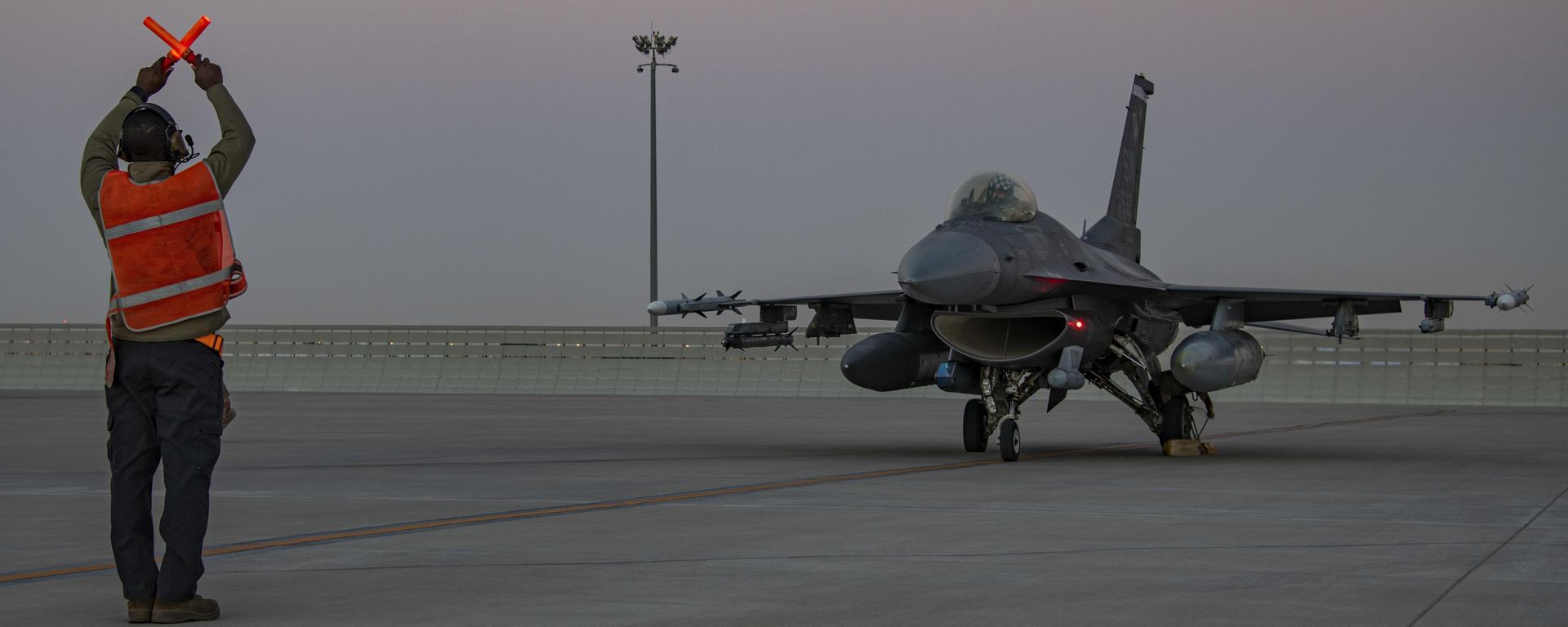 In this handout photo from the U.S. Air Force, an airman guides an F-16 Fighting Falcon during training at Al-Udeid Air Base, Qatar, Jan. 24, 2022.  - Sputnik International, 1920, 29.08.2024