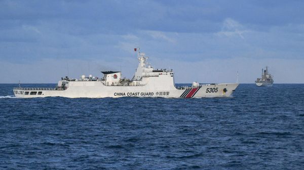 A Chinese Coast Guard ship sails near a Philippine vessel (R) that was part of a convoy of civilian boats in the disputed South China Sea on December 10, 2023.  - Sputnik International