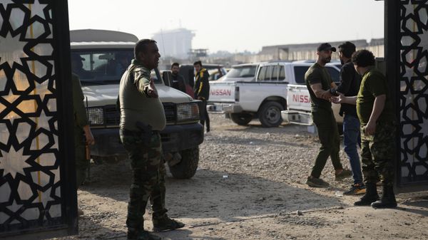 Members of an Iraqi Shiite militant group stand outside the headquarters of the Popular Mobilization Force after it was hit by an airstrike in Baghdad, Iraq, Thursday, Jan. 4, 2024. The Popular Mobilization Force - a coalition of militias that is nominally under the control of the Iraqi military - announced in a statement that its deputy head of operations in Baghdad, Mushtaq Taleb al-Saidi, or Abu Taqwa, had been killed in the strike. - Sputnik International