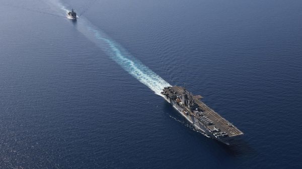 In this photo released by the U.S. Navy, the amphibious assault ship USS Bataan, front, and the landing ship USS Carter Hall, back travel through the Red Sea - Sputnik International
