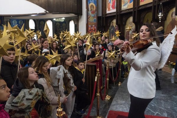 Children holding sticks decorated with stars sing religious songs during a religious service to celebrate Orthodox Christmas in St. Clement Cathedral in Skopje, North Macedonia. - Sputnik International