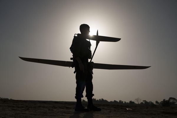 An Israeli troop stands against the silhouette of the Sun as he prepares a small spy drone for launch near Gaza. - Sputnik International