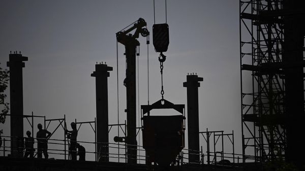 Construction workers are silhouetted against the sky at a construction site in Berlin on September 26, 2023. - Sputnik International