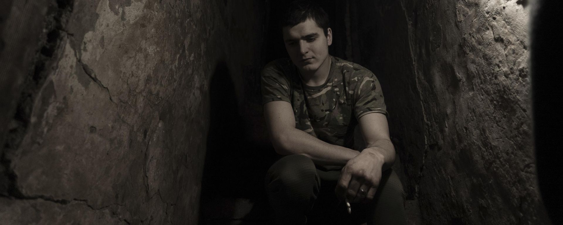 A Ukrainian serviceman smokes in a shelter at a position at the line of separation. A Ukrainian serviceman smokes in a shelter at a position at the line of separation. - Sputnik International, 1920, 22.03.2024