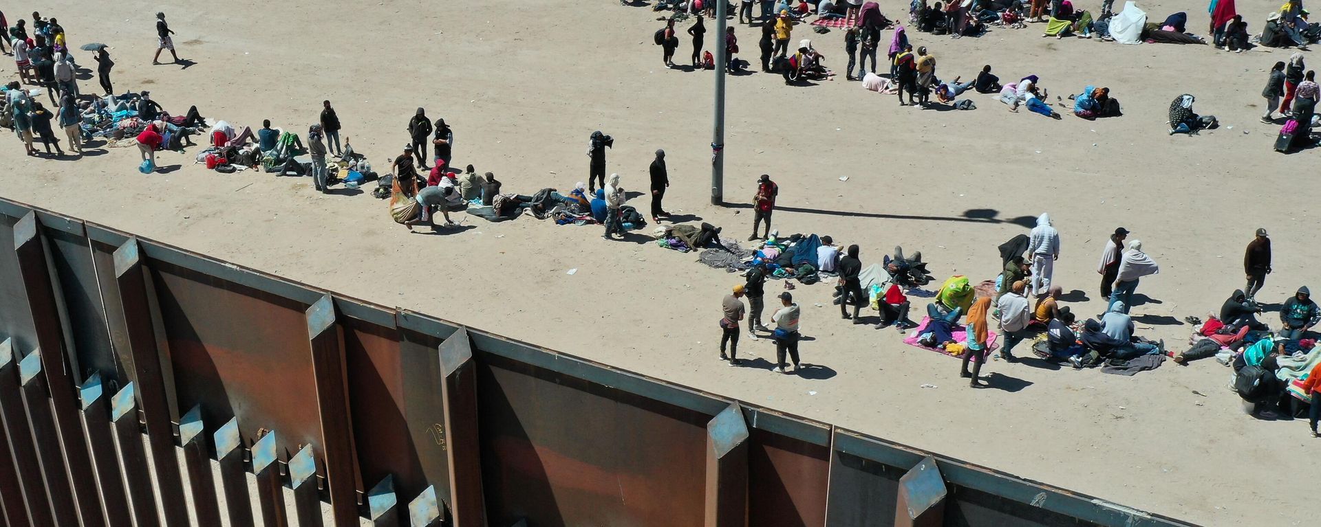 An aerial image shows migrants waiting along the border wall to surrender to Border Patrol agents for immigration and asylum claim processing after crossing the Rio Grande river into the US on the US-Mexico border in El Paso, Texas on May 11, 2023 An aerial image shows migrants waiting along the border wall to surrender to Border Patrol agents for immigration and asylum claim processing after crossing the Rio Grande river into the US on the US-Mexico border in El Paso, Texas on May 11, 2023 - Sputnik International, 1920, 14.02.2024