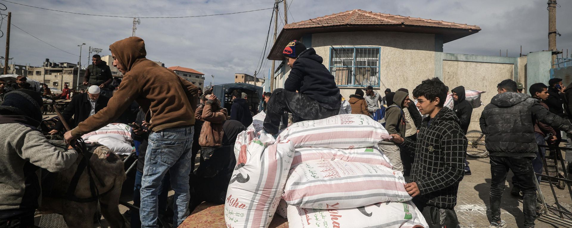 Displaced Palestinians receive food aid at the United Nations Relief and Works Agency for Palestine Refugees (UNRWA) center in Rafah in the southern Gaza Strip on January 28, 2024, amid ongoing battles between Israel and the Palestinian militant group Hamas - Sputnik International, 1920, 29.01.2024
