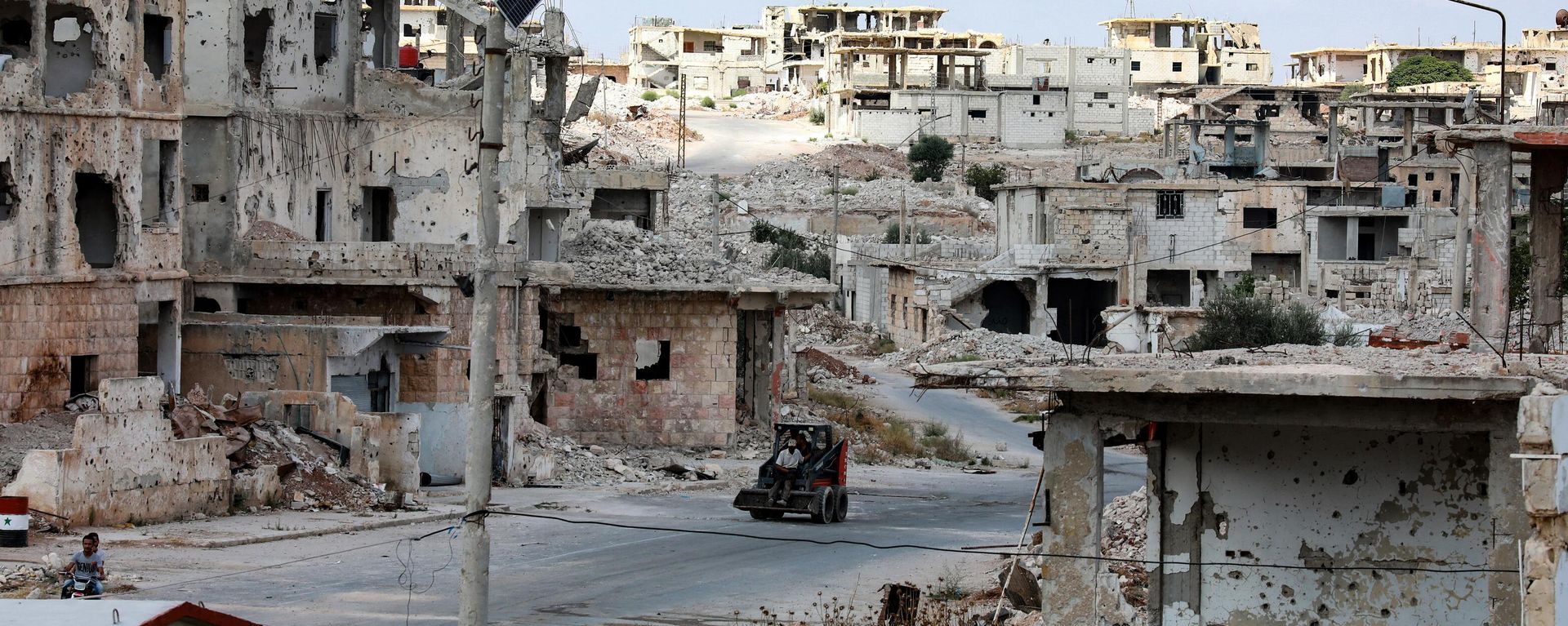 A picture taken during a tour organised by the Syrian Ministry of Information shows a bulldozer in the midst of destruction in the district of Daraa al-Balad of Syria's southern city of Daraa, on September 12, 2021 A picture taken during a tour organised by the Syrian Ministry of Information shows a bulldozer in the midst of destruction in the district of Daraa al-Balad of Syria's southern city of Daraa, on September 12, 2021 - Sputnik International, 1920, 30.01.2024
