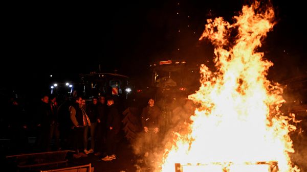 French farmers stand next to a fire as they settle to a new place to block the road, to get closer to Rungis wholesale food market, during a protest on the A6 highway near Chilly-Mazarin, south of Paris. - Sputnik International