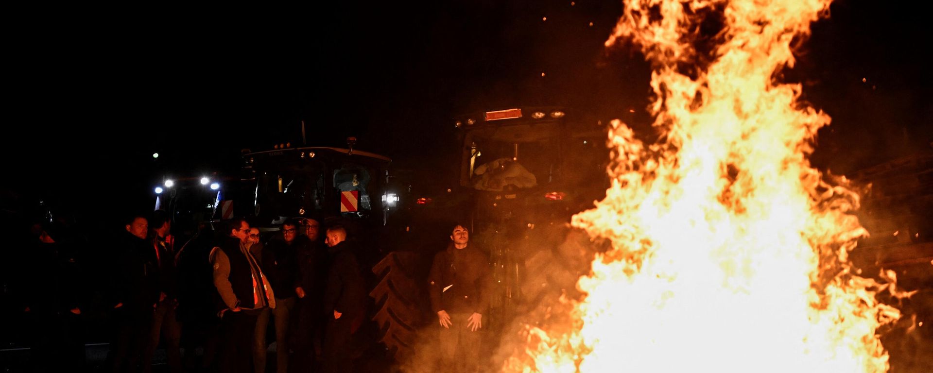 French farmers stand next to a fire as they settle to a new place to block the road, to get closer to Rungis wholesale food market, during a protest on the A6 highway near Chilly-Mazarin, south of Paris. French farmers stand next to a fire as they settle to a new place to block the road, to get closer to Rungis wholesale food market, during a protest on the A6 highway near Chilly-Mazarin, south of Paris. - Sputnik International, 1920, 22.02.2024
