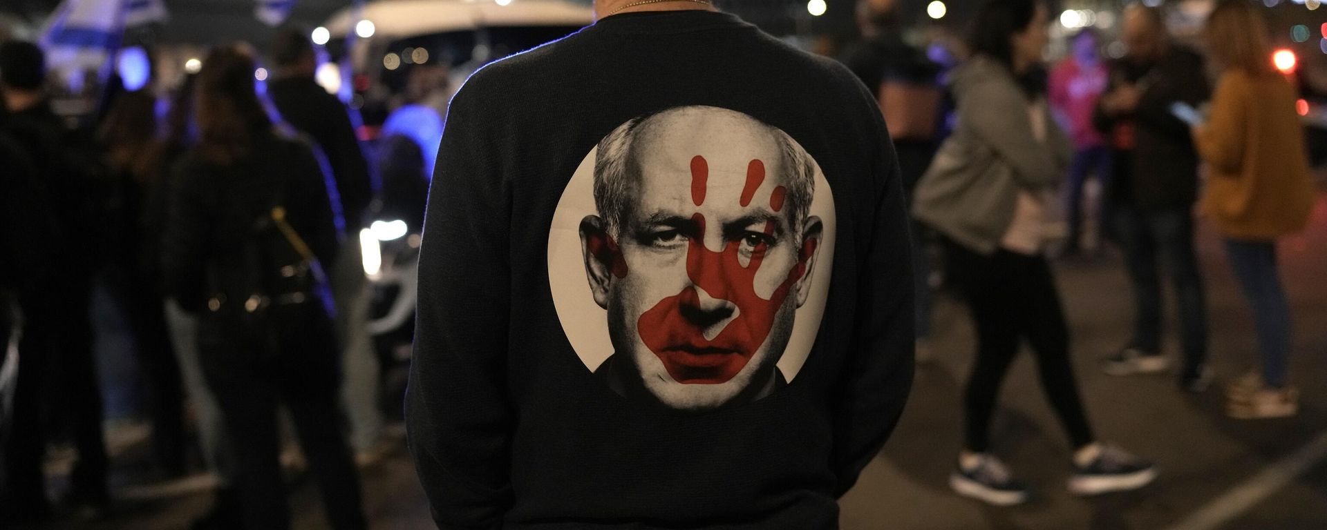A protester wears a shirt depicting Israeli Prime Minister Benjamin Netanyahu attempt during a demonstration to demand the release of the hostages taken by Hamas militants into the Gaza Strip A protester wears a shirt depicting Israeli Prime Minister Benjamin Netanyahu attempt during a demonstration to demand the release of the hostages taken by Hamas militants into the Gaza Strip - Sputnik International, 1920, 01.02.2024