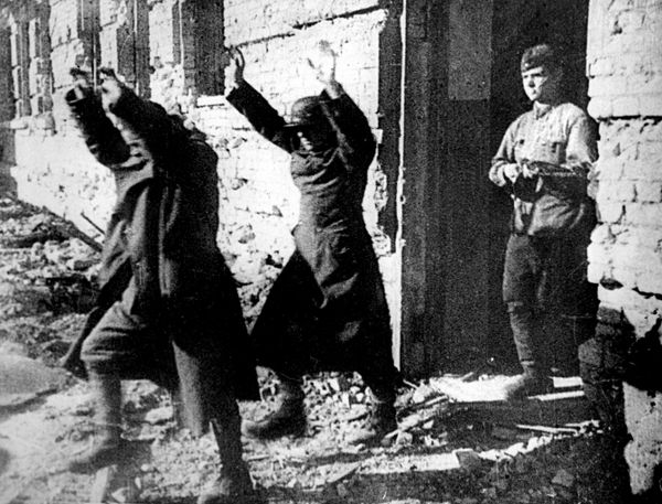 Two surrendering Axis troops, holding their hands up, are marched out of a war-ravaged building by one of their Russian captors as the Third Reich's soldiers face defeat in Stalingrad. - Sputnik International