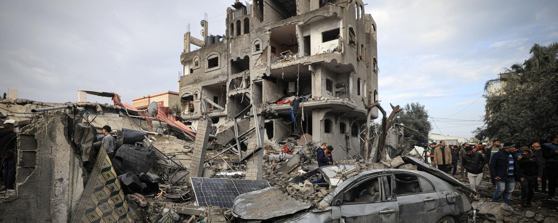 Palestinians inspect the damage at the Al-Maghazi refugee camp after an overnight Israeli strike on December 25, 2023, amid ongoing battles between Israel and the Palestinian militant group Hamas Palestinians inspect the damage at the Al-Maghazi refugee camp after an overnight Israeli strike on December 25, 2023, amid ongoing battles between Israel and the Palestinian militant group Hamas - Sputnik International, 1920, 07.02.2024