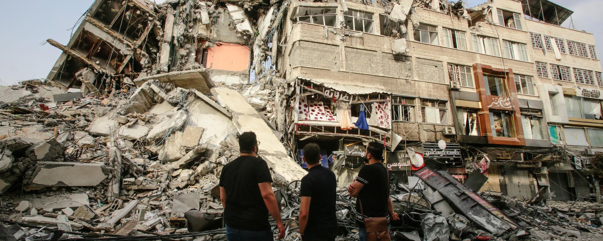 Palestinians look at ruins of a residential building - Sputnik International, 1920, 19.03.2024