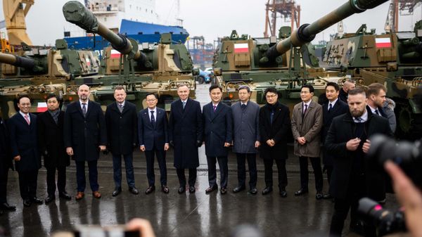 Polish President Andrzej Duda (6L), Minister of South Korea's state arms procurement agency Eom Donghwan (7L) and Polish Defence Minister Mariusz Blaszczak (4L) pose with officials during the acceptance of the first South Korean K2 battle tanks and South Korean K9 howitzers for Poland in December 6, 2022 at the Baltic Container Terminal in Gdynia.  - Sputnik International