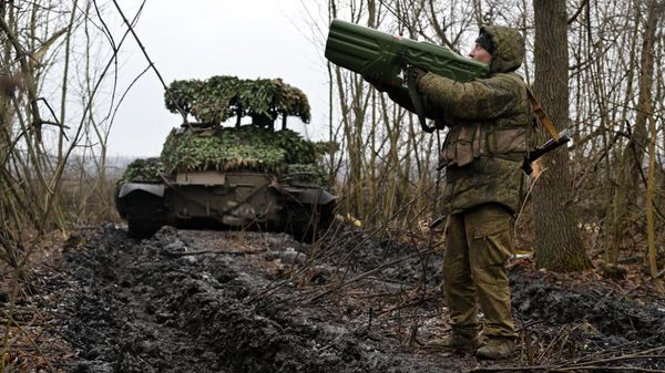 Russian Armed Forces serviceman with an anti-drone gun near a T-62 tank. - Sputnik International