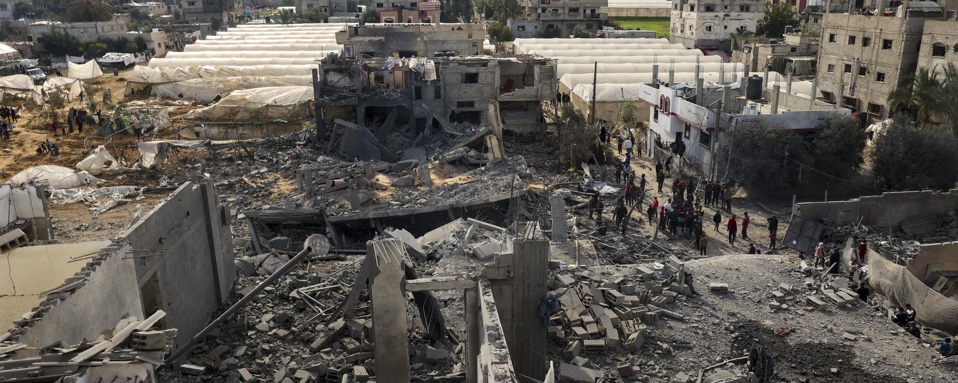 Palestinians inspect the damage amid the rubble of a building where two hostages were reportedly held before being rescued during an operation by Israeli security forcess in Rafah, on the southern Gaza Strip on February 12, 2024, amid ongoing battles between Israel and the militant group Hamas - Sputnik International, 1920, 15.02.2024