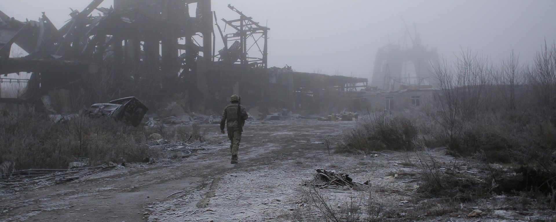 A Ukrainian soldier passes by a destroyed Butovka coal mine as he approaches his front line position in the town of Avdeyevka in the Donetsk region - Sputnik International, 1920, 31.05.2024