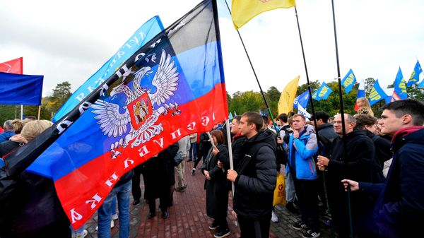 People wave flags during a concert on the day of new regions' reunification with Russia - Sputnik International
