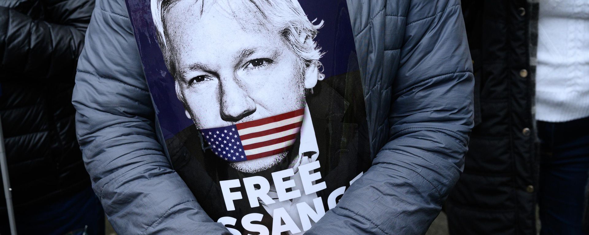 A supporter of Julian Assange holds a placard as she stands outside Westminster Magistrates Court - Sputnik International, 1920, 26.03.2024