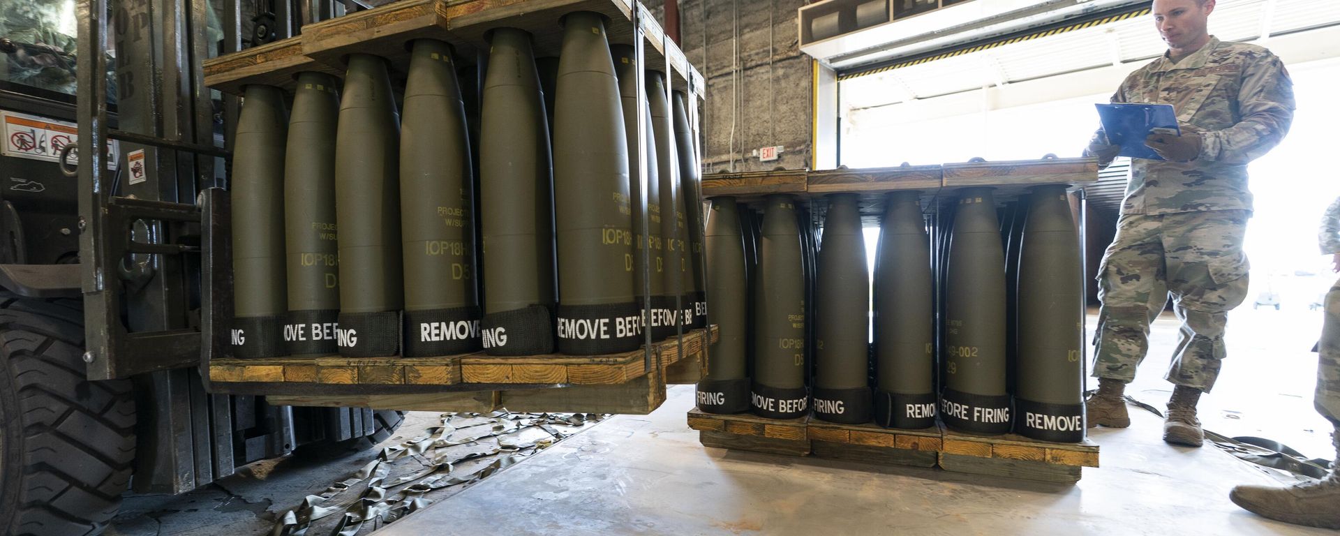 U.S. Air Force Staff Sgt. Cody Brown, right, with the 436th Aerial Port Squadron, checks pallets of 155 mm shells ultimately bound for Ukraine, April 29, 2022, at Dover Air Force Base, Del.  - Sputnik International, 1920, 14.03.2024