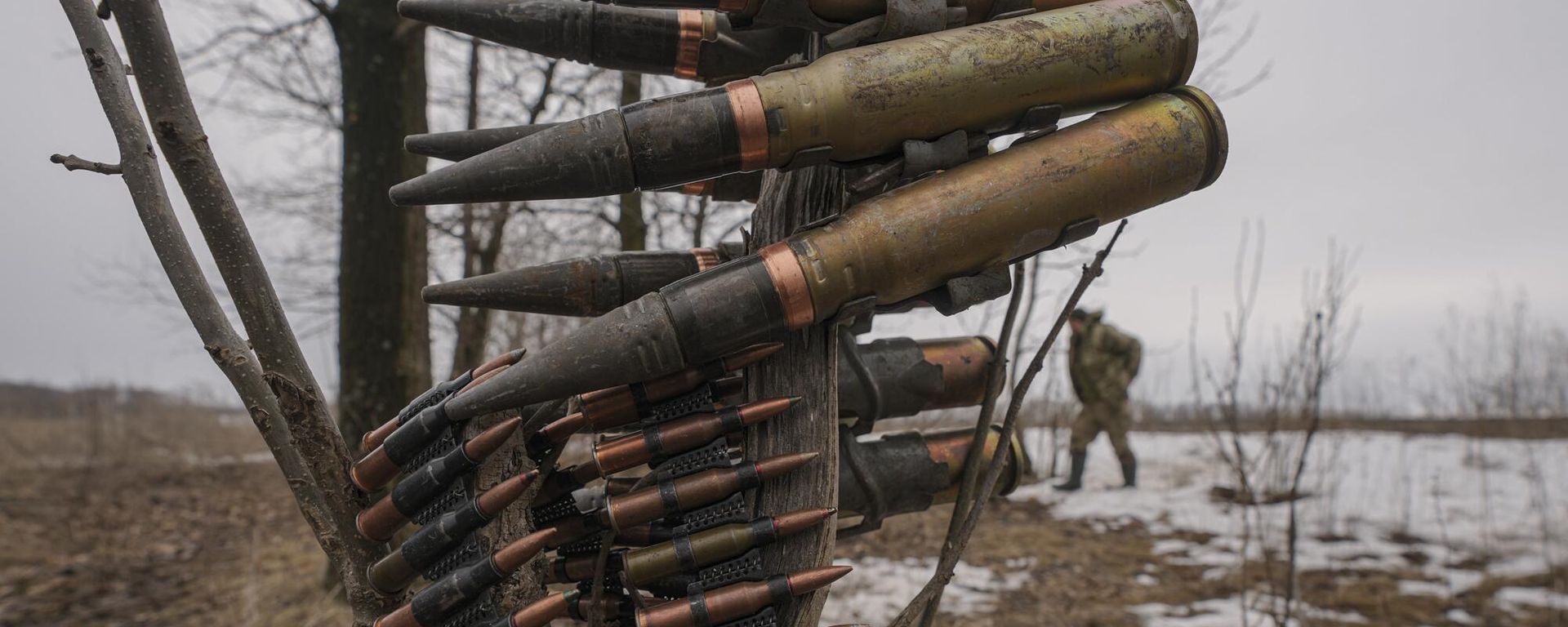 Ammunition is hanging from a tree branch as a Ukrainian serviceman walks by during an exercise in a Joint Forces Operation controlled area in the Donetsk region - Sputnik International, 1920, 14.03.2024
