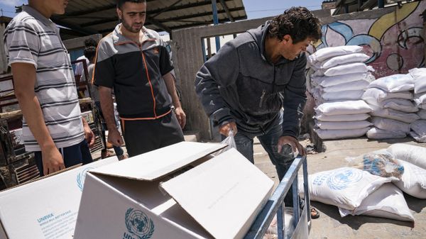 Bags of foodstuffs provided by the United Nations Relief and Works Agency for Palestine Refugees in the Near East (UNRWA) as Palestinians collect food aid following a cease-fire reached after an 11-day war between Gaza's Hamas rulers and Israel, in Gaza City, Saturday, May 22, 2021 - Sputnik International