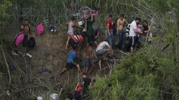 Migrants walk up the bank on the U.S. side of the Rio Grande river, as seen from Matamoros, Mexico, Wednesday, May 10, 2023 - Sputnik International