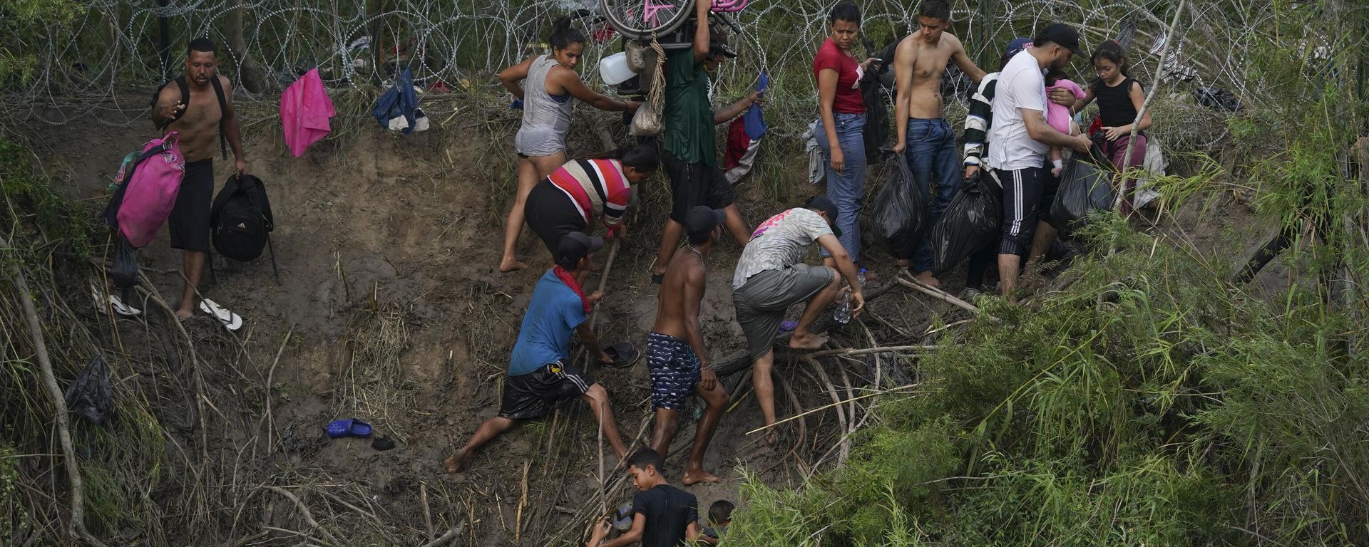 Migrants walk up the bank on the U.S. side of the Rio Grande river, as seen from Matamoros, Mexico, Wednesday, May 10, 2023 - Sputnik International, 1920, 26.02.2024