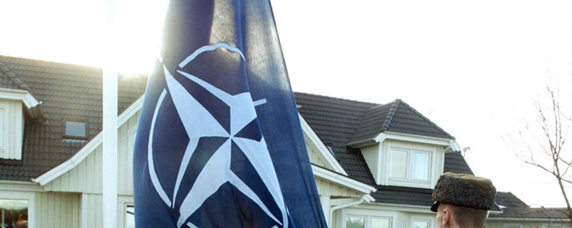 An Estonian soldier holds NATO flag in front of the former Estonian President Lennart Meri's house in Tallinn 29 March 2004. - Sputnik International, 1920, 08.03.2024