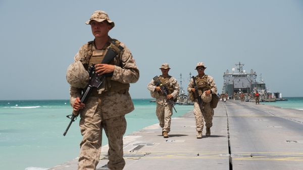 U.S. Marines walk down a removable Trident Pier leading to an American ship docked near an Emirati military base home to a Military Operations and Urban Terrain facility in al-Hamra, United Arab Emirates, Monday, March 23, 2020 U.S. Marines walk down a removable Trident Pier leading to an American ship docked near an Emirati military base home to a Military Operations and Urban Terrain facility in al-Hamra, United Arab Emirates, Monday, March 23, 2020 - Sputnik International