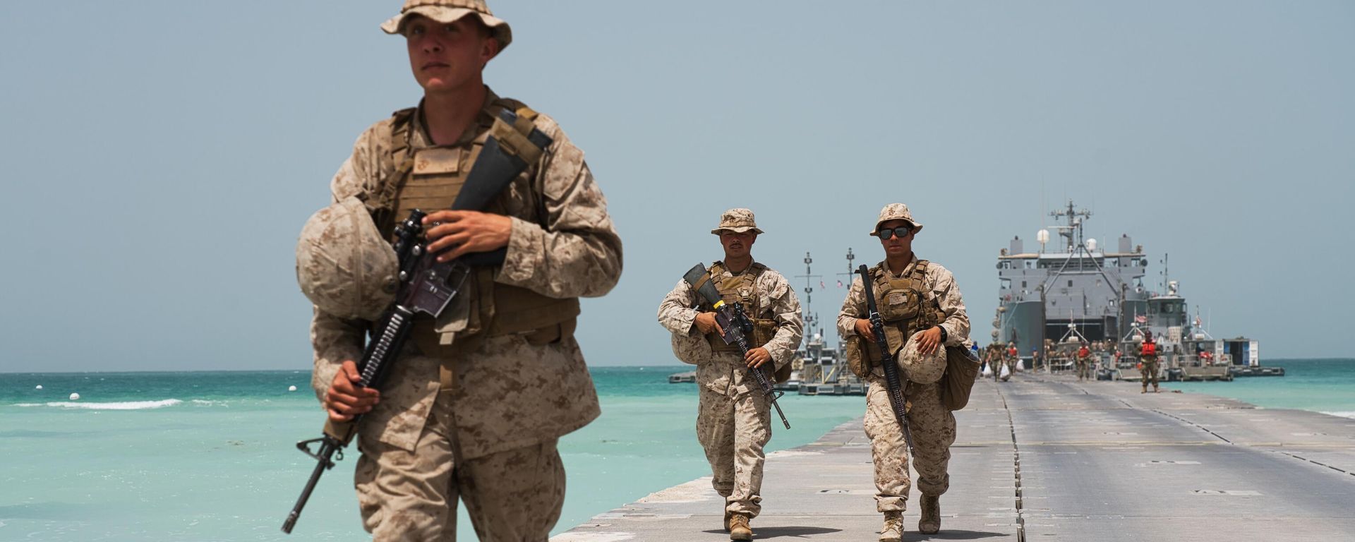 U.S. Marines walk down a removable Trident Pier leading to an American ship docked near an Emirati military base home to a Military Operations and Urban Terrain facility in al-Hamra, United Arab Emirates, Monday, March 23, 2020 - Sputnik International, 1920, 08.06.2025
