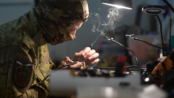 A drone pilot assembles drones at a facility  - Sputnik International
