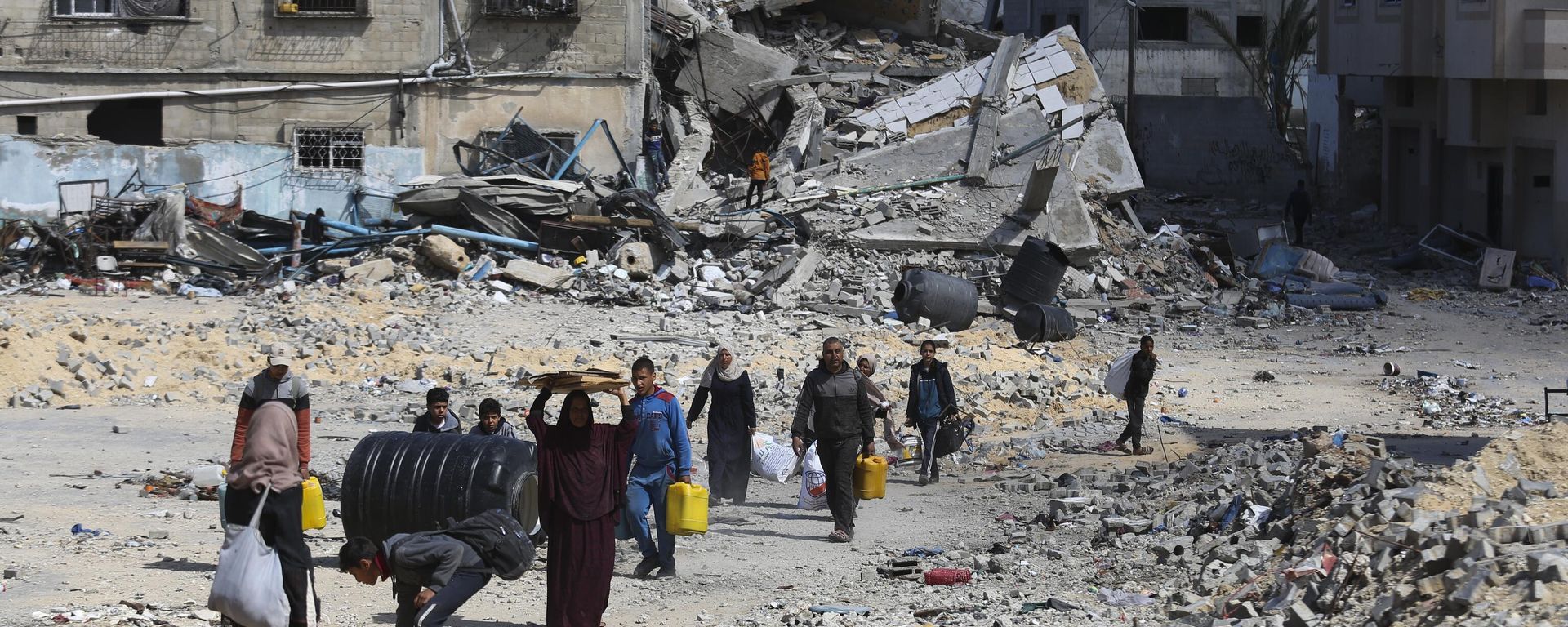 Palestinians walk through the destruction left by the Israeli offensive on Khan Younis, Gaza Strip - Sputnik International, 1920, 13.03.2024