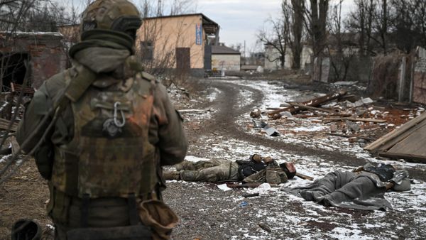 A Russian serviceman of the Central Military District stands next to bodies of dead Ukrainian soldiers amid Russia's military operation in Ukraine in the town of Avdeyevka near Donetsk, Donetsk People's Republic, Russia - Sputnik International