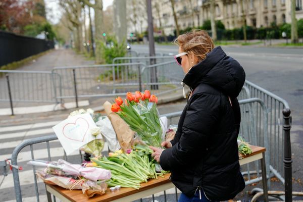 A woman holds a bunch of flowers at a makeshift memorial in front of Russia's Embassy in Paris.  - Sputnik International