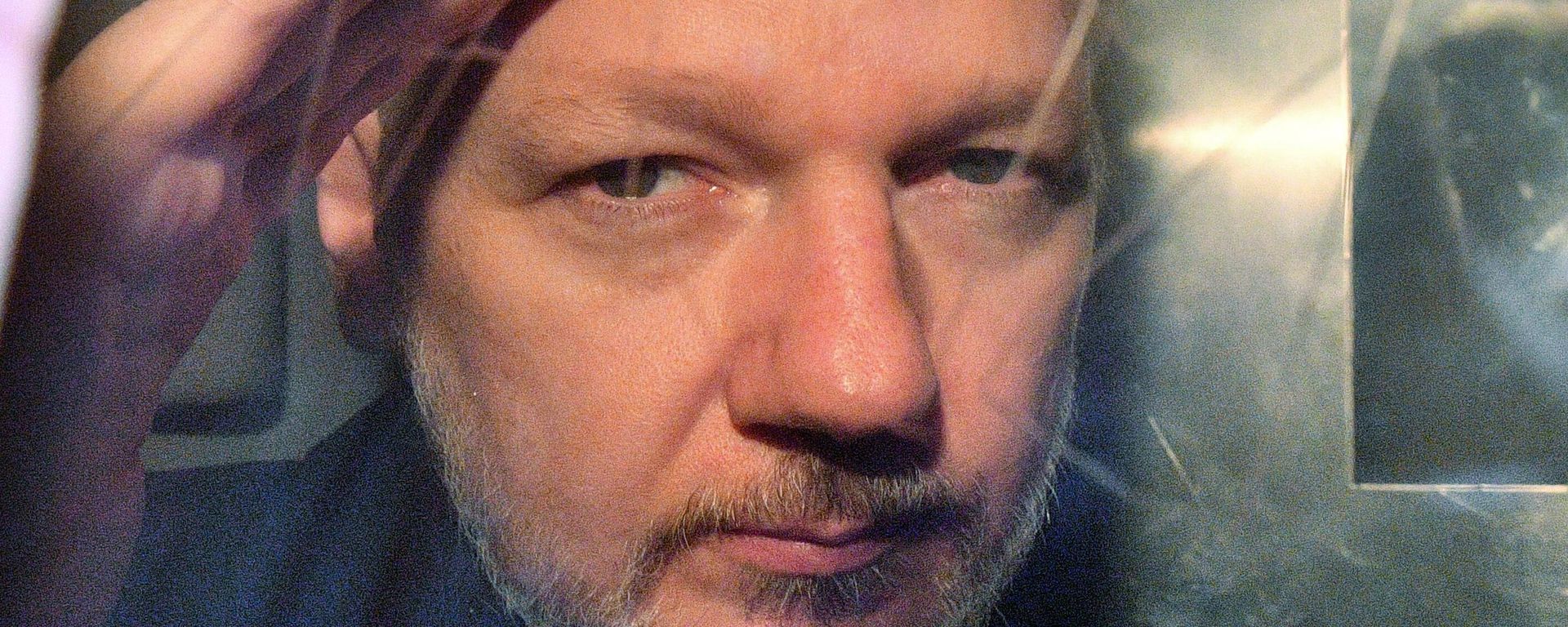 WikiLeaks founder Julian Assange gestures from the window of a prison van as he is driven out of Southwark Crown Court in London on May 1, 2019, after having been sentenced to 50 weeks in prison for breaching his bail conditions in 2012.  - Sputnik International, 1920, 10.04.2024